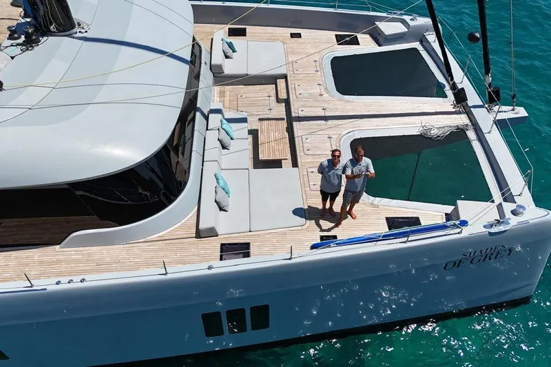 Shades Of Grey Yacht Photos Pics 2024 Sunreef 80 sailing yacht with spacious deck and lounging area on turquoise water.