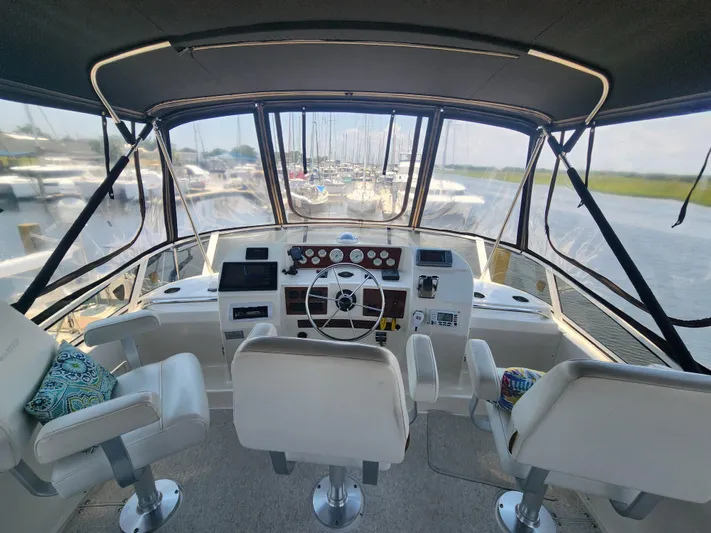 Nacho Boat Yacht Photos Pics Interior view of 2000 Silverton 453 Motor Yacht helm with steering wheel and seating.