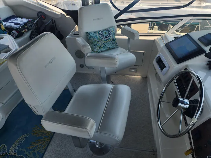Nacho Boat Yacht Photos Pics Captain's chairs and helm of 2000 Silverton 453 Motor Yacht, featuring modern controls and steering wheel.