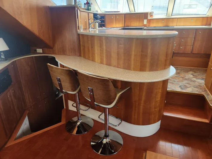 Nacho Boat Yacht Photos Pics Interior of 2000 Silverton 453 Motor Yacht with wooden cabinetry and bar stools.