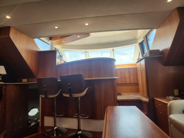 Nacho Boat Yacht Photos Pics Interior of 2000 Silverton 453 Motor Yacht with wooden cabinetry and bar stools.