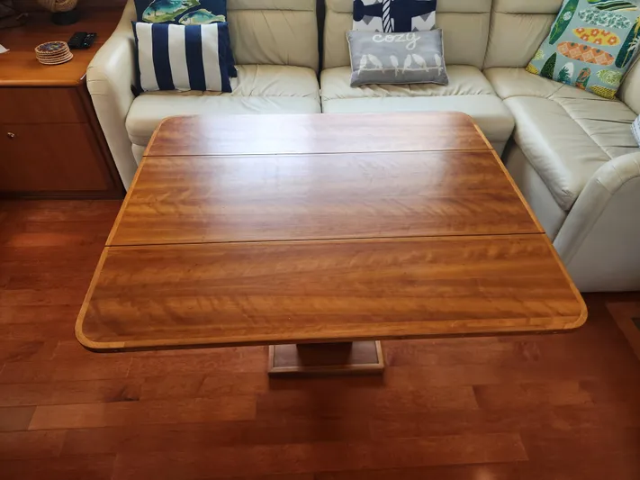 Nacho Boat Yacht Photos Pics Wooden table in a 2000 Silverton 453 Motor Yacht interior, surrounded by a white sofa.