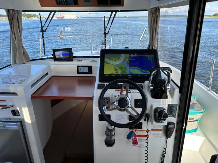Inspector Gadget Yacht Photos Pics Helm of 2016 Jeanneau Merry Fisher 855 Marlin with navigation equipment and water view.