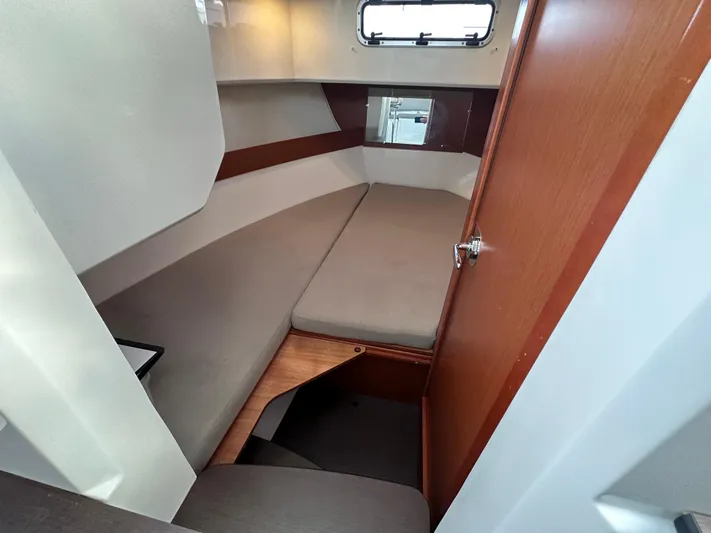 Inspector Gadget Yacht Photos Pics Cabin interior of 2016 Jeanneau Merry Fisher 855 Marlin with cozy bed and wooden accents.