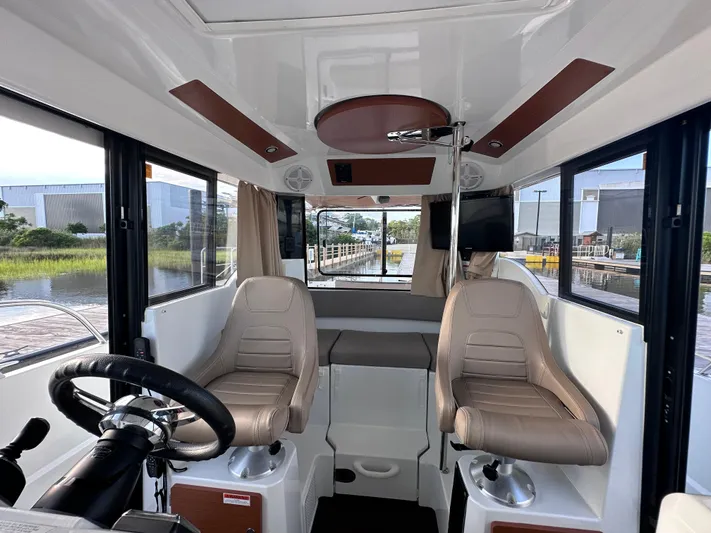 Inspector Gadget Yacht Photos Pics Interior of 2016 Jeanneau Merry Fisher 855 Marlin boat with steering wheel and seating.