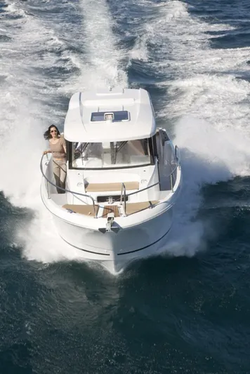 Inspector Gadget Yacht Photos Pics 2016 Jeanneau Merry Fisher 855 Marlin cruising on open water, with a person on deck.