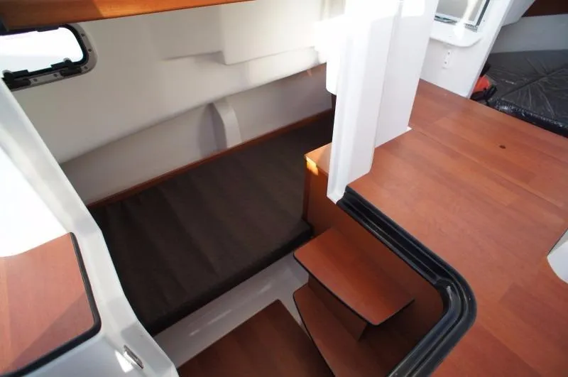 Inspector Gadget Yacht Photos Pics Interior of 2016 Jeanneau Merry Fisher 855 Marlin, featuring wooden steps and cozy cabin space.