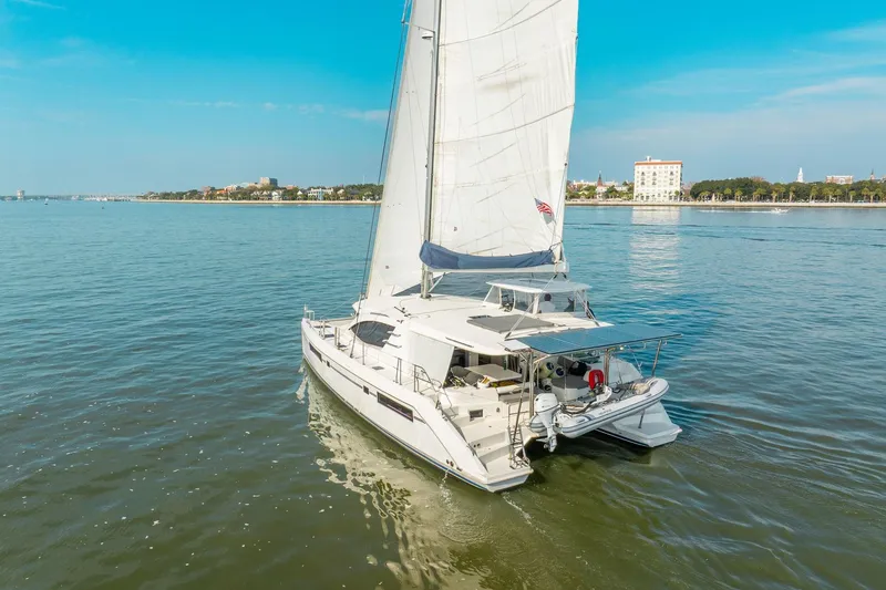 Grace Yacht Photos Pics 2016 Leopard 48 yacht sailing near a coastal city under clear blue skies.