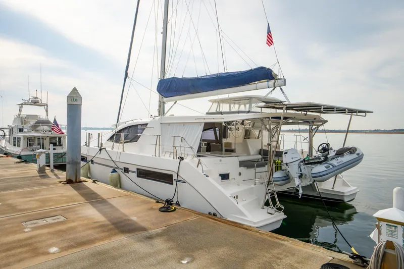 Grace Yacht Photos Pics 2016 Leopard 48 yacht docked with dinghy, featuring sleek design and American flag.