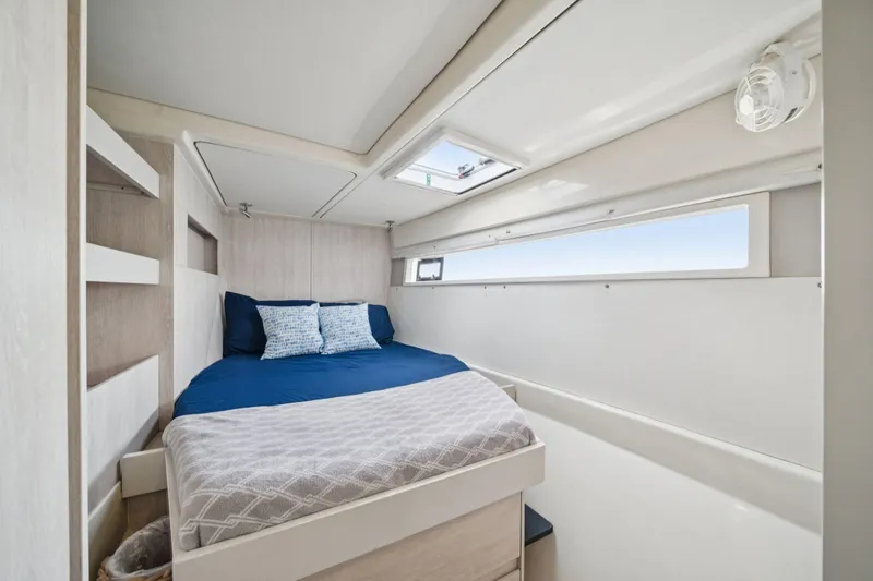 Grace Yacht Photos Pics Cozy bedroom interior on 2016 Leopard 48 yacht with blue bedding and natural light.