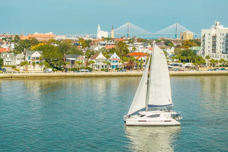 Grace Yacht Photos Pics Sailboat Leopard 48 cruising near colorful waterfront homes and bridge, 2016 model.
