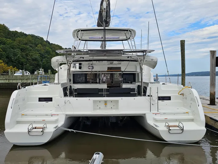  Yacht Photos Pics 2024 Lagoon 46 catamaran docked at a marina, rear view.