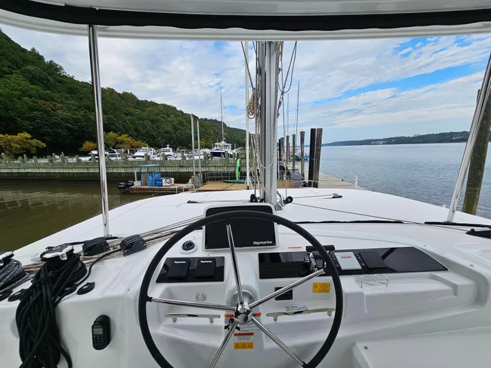  Yacht Photos Pics 2024 Lagoon 46 yacht helm with marina view, featuring modern navigation equipment.