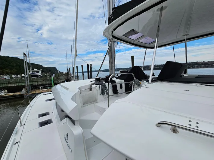  Yacht Photos Pics 2024 Lagoon 46 catamaran docked at a marina with scenic water views.