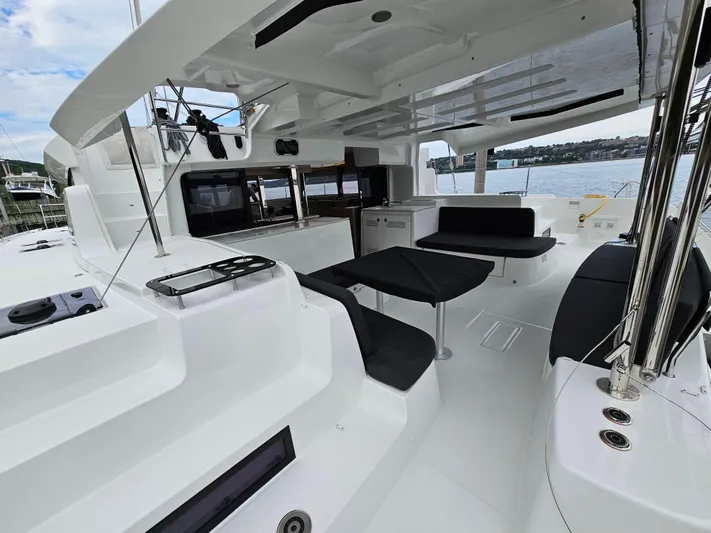  Yacht Photos Pics 2024 Lagoon 46 yacht with spacious deck, modern seating, and scenic water view.