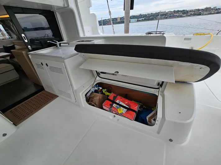  Yacht Photos Pics 2024 Lagoon 46 yacht with open storage compartment on deck, revealing various items inside.