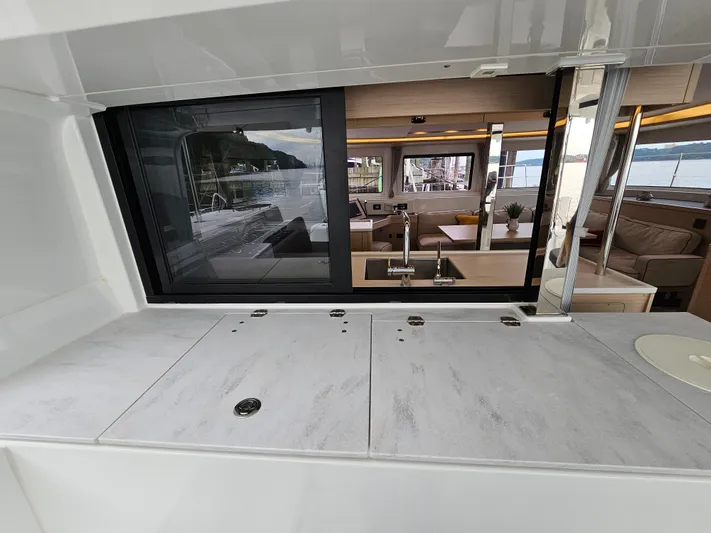  Yacht Photos Pics 2024 Lagoon 46 yacht interior with modern kitchen and scenic window view.
