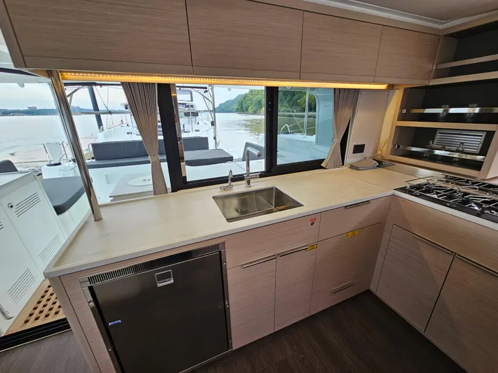  Yacht Photos Pics Modern kitchen interior of 2024 Lagoon 46 yacht with sleek design and outdoor view.