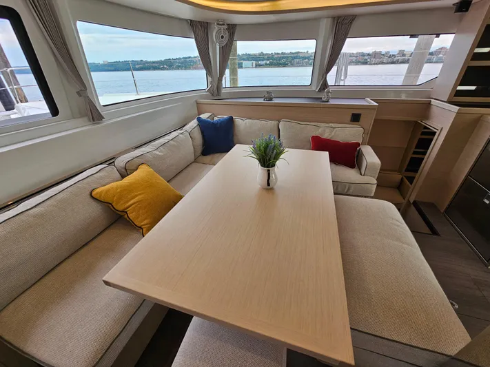  Yacht Photos Pics Interior of 2024 Lagoon 46 yacht with cozy seating and colorful cushions.
