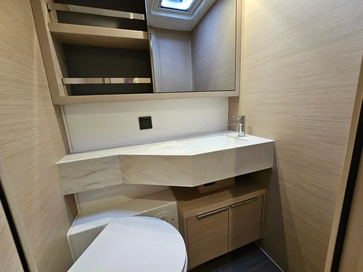 Yacht Photos Pics Modern bathroom interior in 2024 Lagoon 46 yacht with sleek design and wooden finishes.