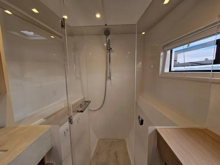  Yacht Photos Pics Modern bathroom interior of 2024 Lagoon 46 yacht with glass shower and sleek design.