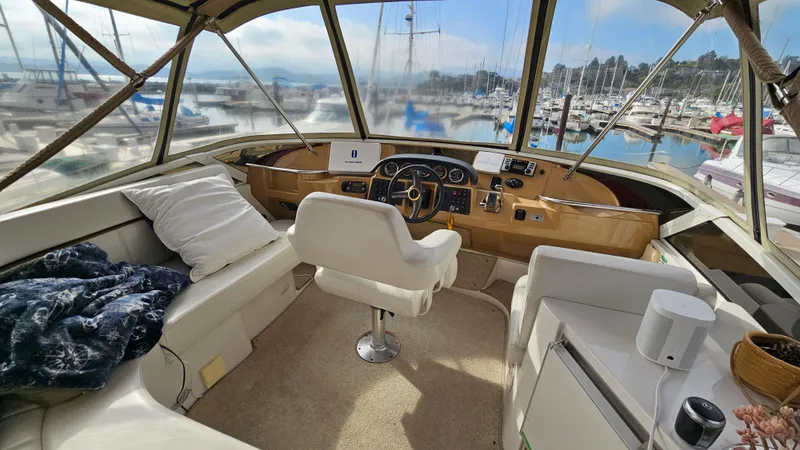 Ada Yacht Photos Pics 2002 Carver 396 Motor Yacht interior with helm, seating, and marina view.