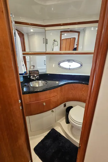 Ada Yacht Photos Pics 2002 Carver 396 Motor Yacht bathroom with sink, toilet, and wooden cabinetry.