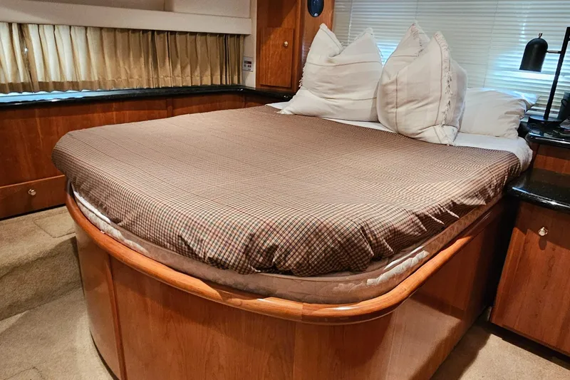 Ada Yacht Photos Pics Luxurious bedroom interior of 2002 Carver 396 Motor Yacht with cozy bedding and elegant wood finish.