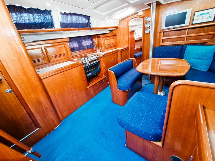  Yacht Photos Pics Interior of 2004 Beneteau Oceanis 423 yacht with wooden cabinetry and blue upholstery.