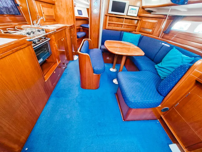  Yacht Photos Pics Interior of 2004 Beneteau Oceanis 423 yacht with blue seating and wooden finishes.