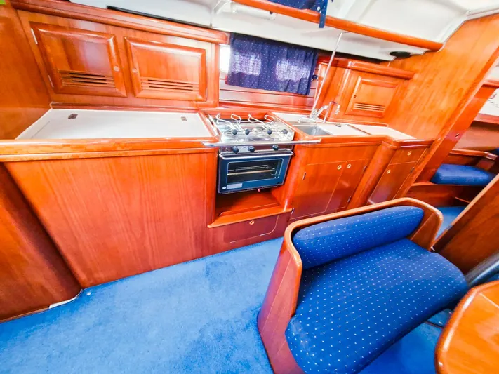  Yacht Photos Pics Interior of 2004 Beneteau Oceanis 423 yacht with wooden cabinetry and blue seating.