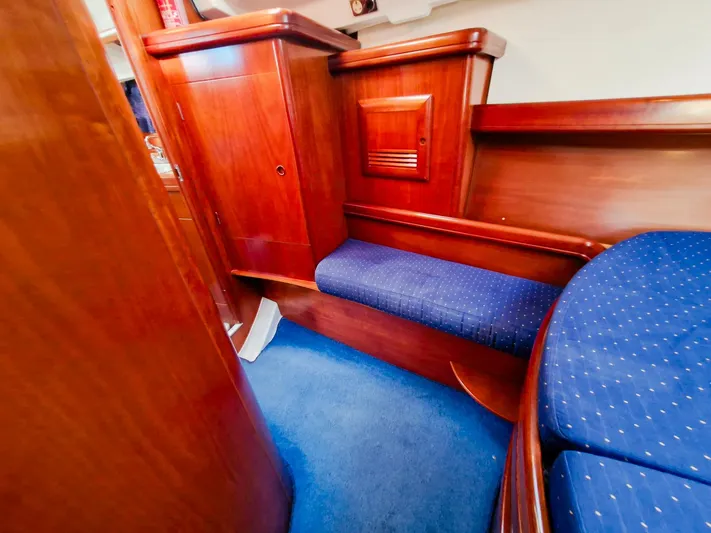  Yacht Photos Pics Interior of 2004 Beneteau Oceanis 423 yacht with wooden cabinetry and blue upholstery.
