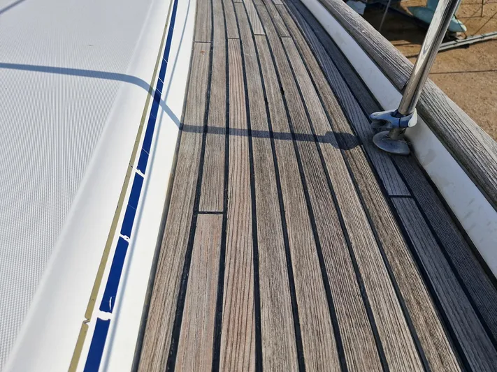  Yacht Photos Pics Teak deck of 2004 Beneteau Oceanis 423 sailboat, showcasing wood grain and metal fittings.