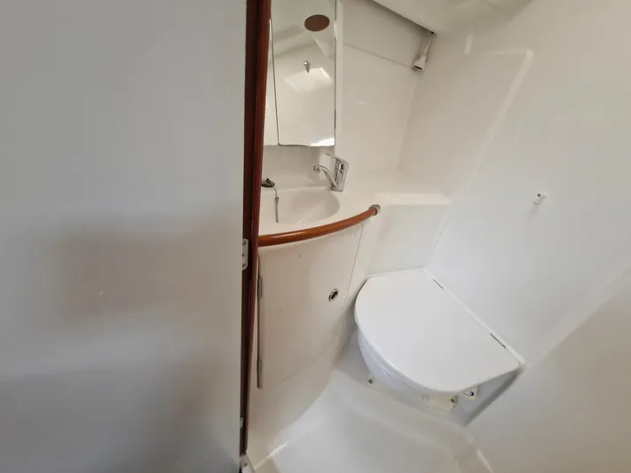  Yacht Photos Pics Bathroom interior of 2004 Beneteau Oceanis 423 yacht, featuring compact design and white fixtures.