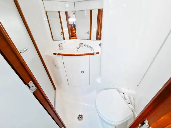  Yacht Photos Pics Bathroom interior of 2004 Beneteau Oceanis 423 yacht, featuring compact design and wooden accents.