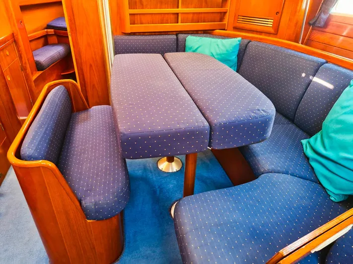 Yacht Photos Pics Interior of 2004 Beneteau Oceanis 423 yacht with blue cushioned seating and wooden finish.