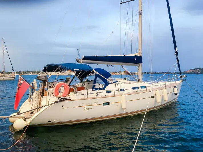  Yacht Photos Pics 2004 Beneteau Oceanis 423 sailboat docked in calm waters, featuring blue canopy and white hull.