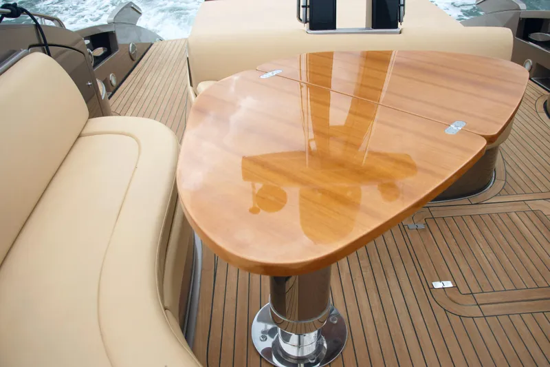  Yacht Photos Pics Luxury Riva Rivale 52 yacht deck with elegant wooden table and beige seating, 2006 model.