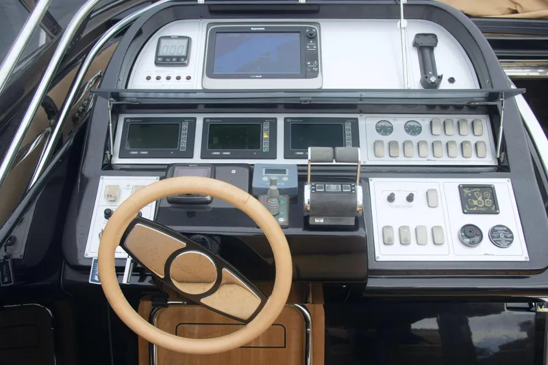  Yacht Photos Pics Control panel of a 2006 Riva Rivale 52 yacht with steering wheel and navigation instruments.