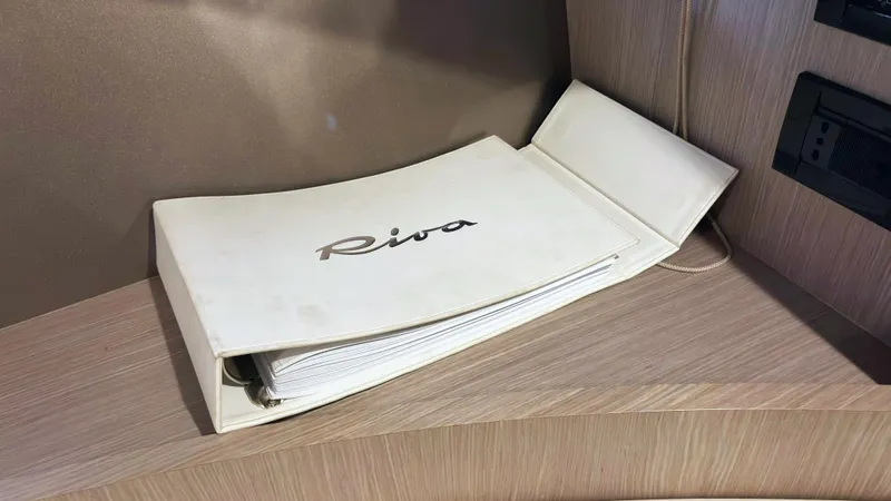  Yacht Photos Pics White Riva binder on wooden surface, associated with 2006 Riva Rivale 52 yacht.