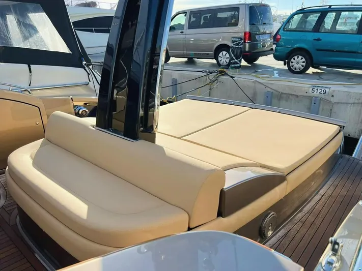  Yacht Photos Pics 2006 Riva Rivale 52 yacht with beige seating, docked near vehicles.