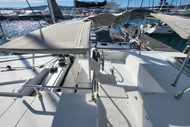  Yacht Photos Pics 2018 Fountaine Pajot Saona 47 catamaran with shaded cockpit, docked in a marina.