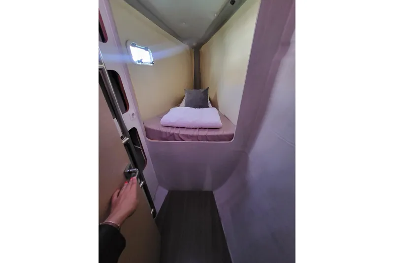  Yacht Photos Pics Cozy cabin interior of 2018 Fountaine Pajot Saona 47 catamaran with bed and porthole.