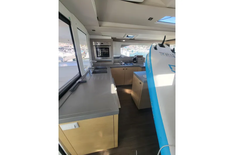  Yacht Photos Pics Interior of 2018 Fountaine Pajot Saona 47 yacht with modern kitchen and surfboard.