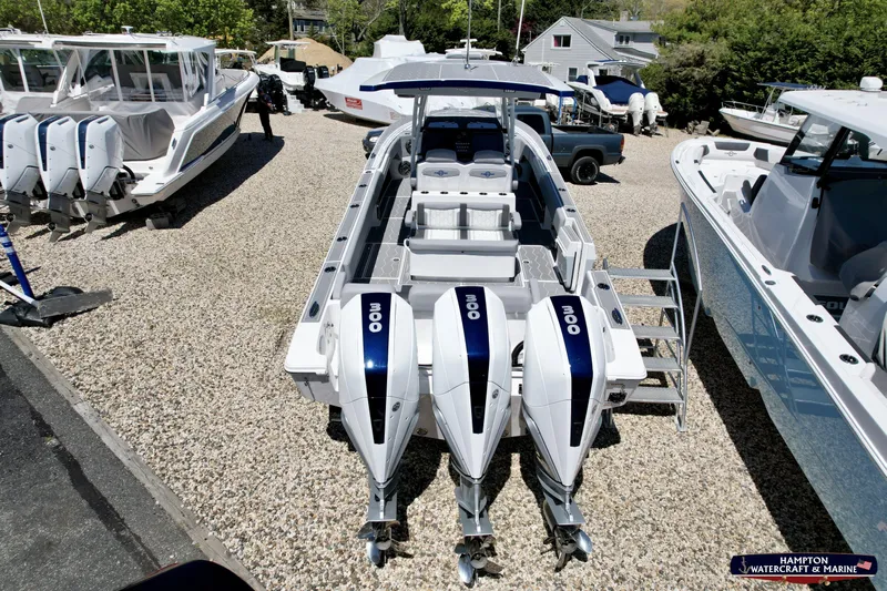 Mundinger Brokerage Yacht Photos Pics 2023 Fountain 34 SC boat with triple outboard engines on display at a marina.