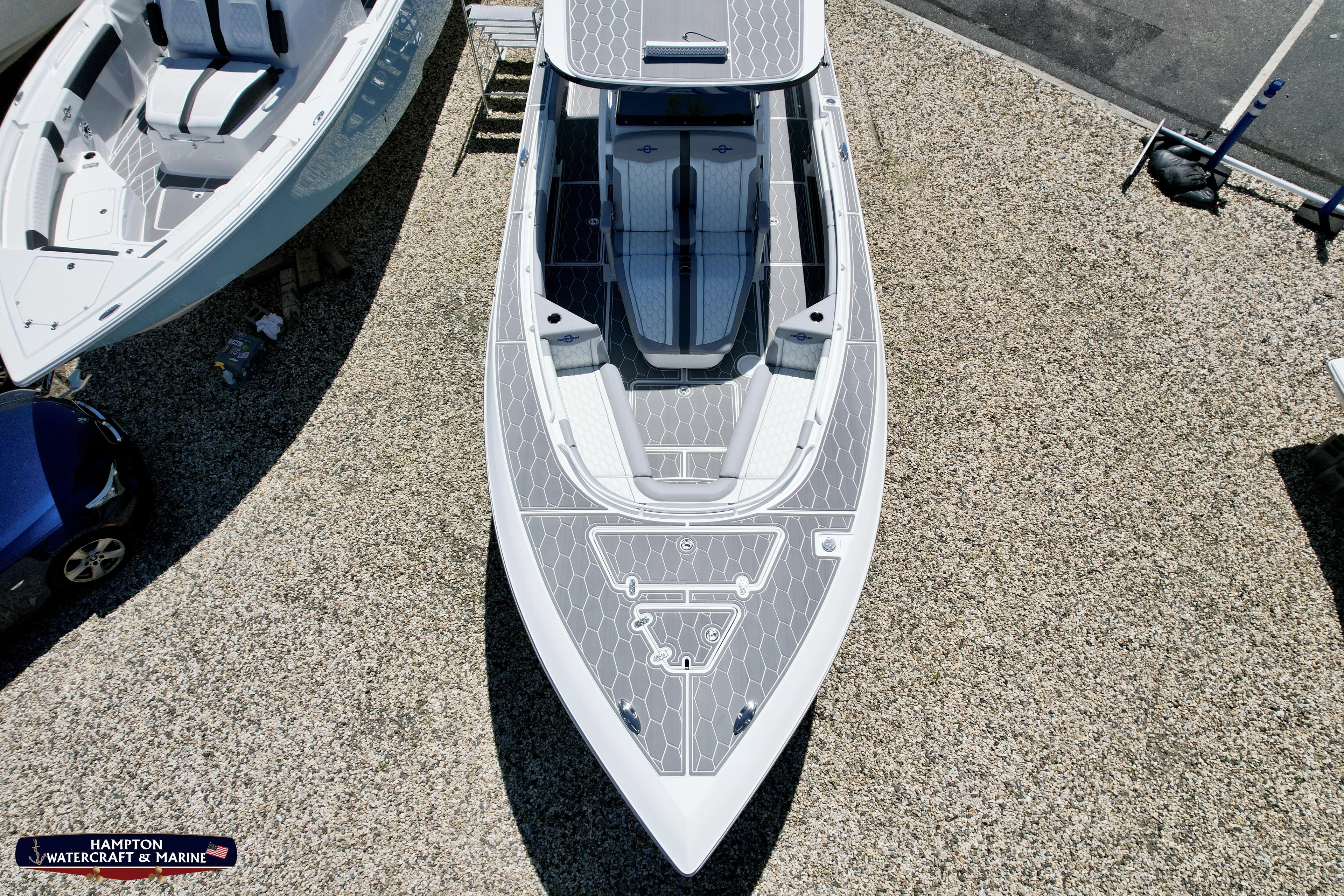 Mundinger Brokerage Yacht Photos Pics 2023 Fountain 34 SC boat, aerial view, sleek design on gravel surface.