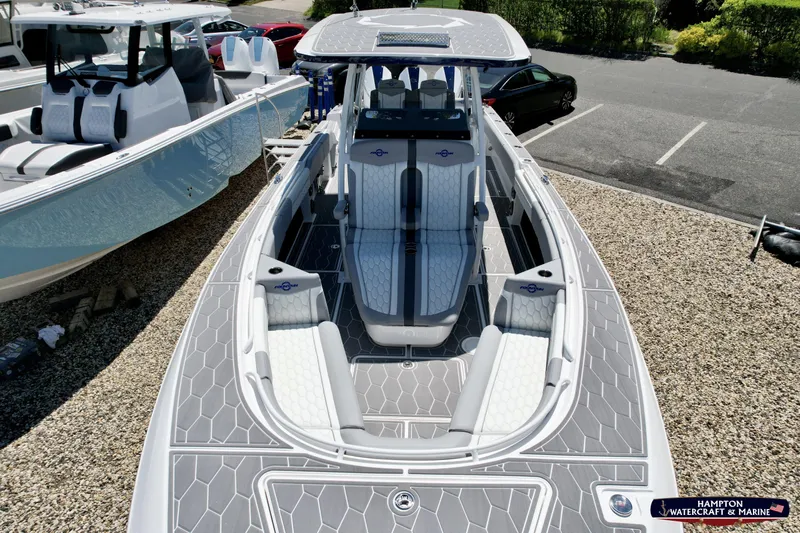 Mundinger Brokerage Yacht Photos Pics 2023 Fountain 34 SC boat with sleek design and spacious seating at a marina.