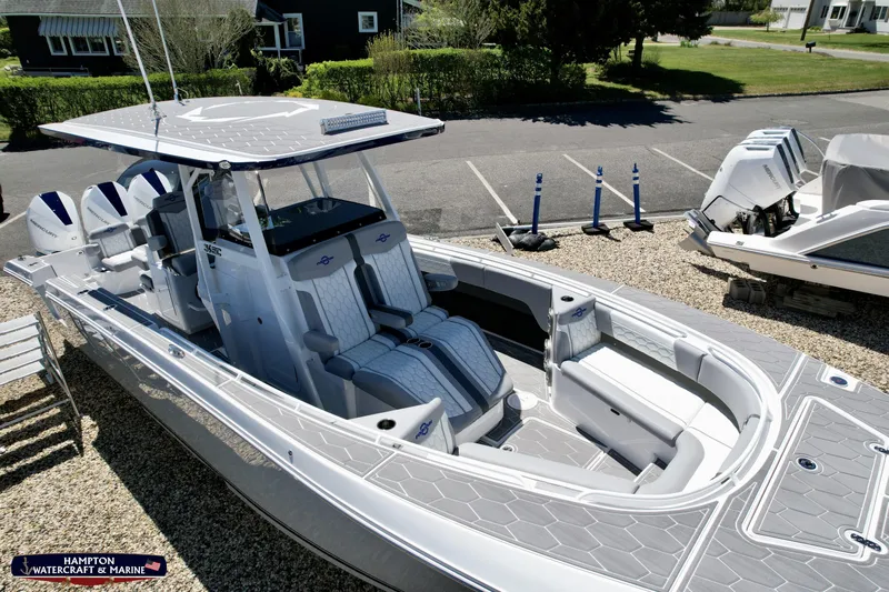 Mundinger Brokerage Yacht Photos Pics 2023 Fountain 34 SC boat with sleek design and spacious seating in a marina setting.