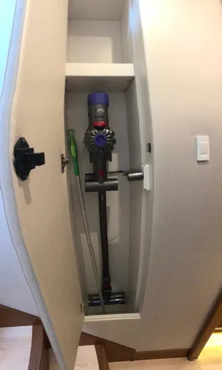 Privateer Yacht Photos Pics Storage compartment with a Dyson vacuum cleaner in a 2019 Jarrett Bay 67 Custom yacht.