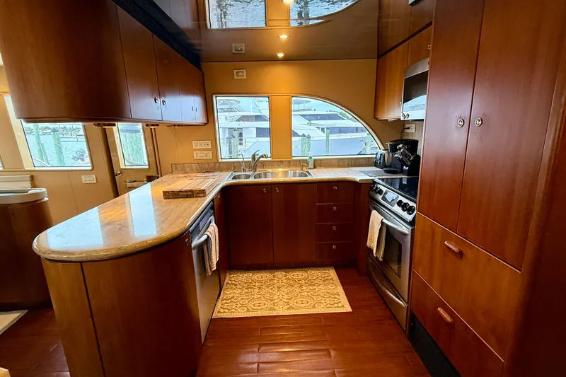 Southern Lady Yacht Photos Pics Luxurious kitchen in 2002 Cheoy Lee 72 Raised Pilot House Motor Yacht, featuring wood cabinetry and modern appliances.